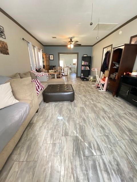 living room featuring light hardwood / wood-style flooring, ceiling fan, and ornamental molding