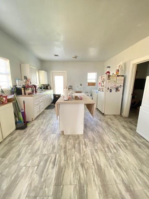 kitchen with white cabinetry and white fridge