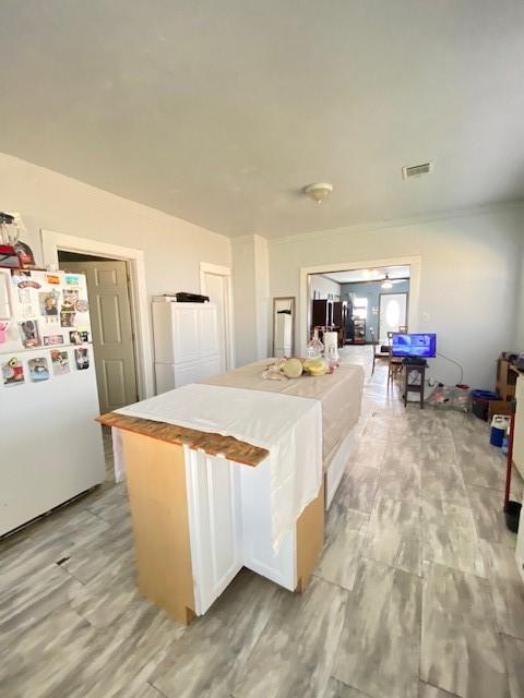 kitchen with white cabinets, white fridge, and ceiling fan