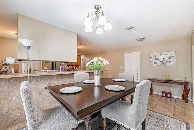 tiled dining area with a chandelier