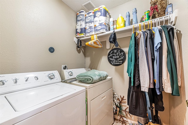 clothes washing area featuring washer and clothes dryer and a textured ceiling