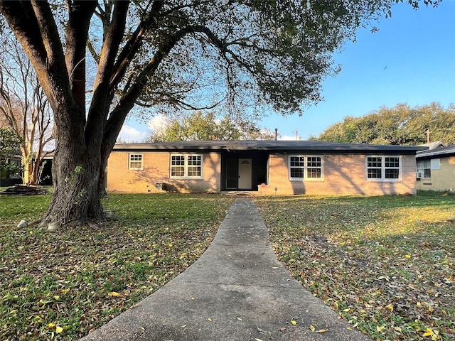 ranch-style house featuring a front yard and brick siding