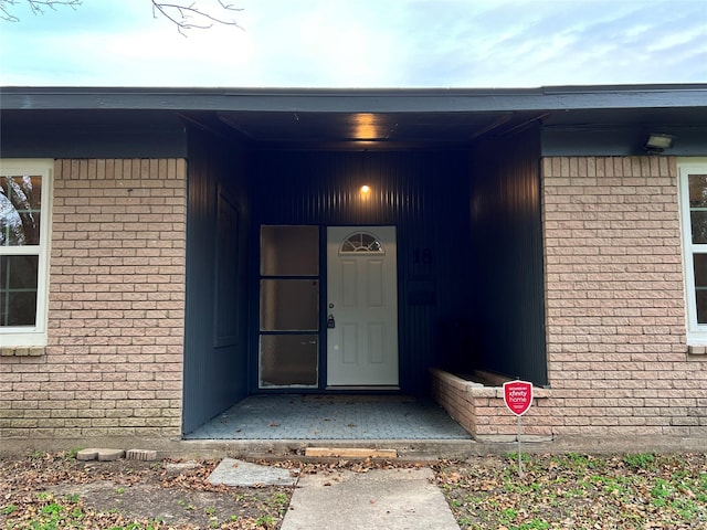 doorway to property with brick siding