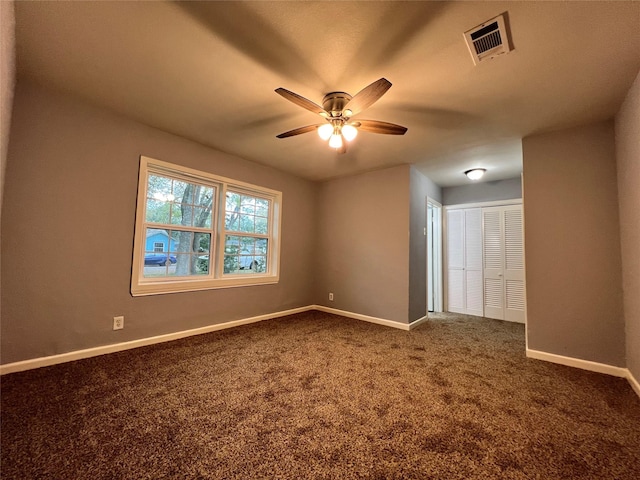 carpeted empty room featuring a ceiling fan, baseboards, and visible vents