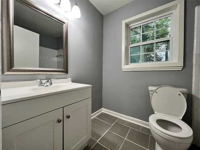 bathroom with vanity, tile patterned floors, toilet, and baseboards