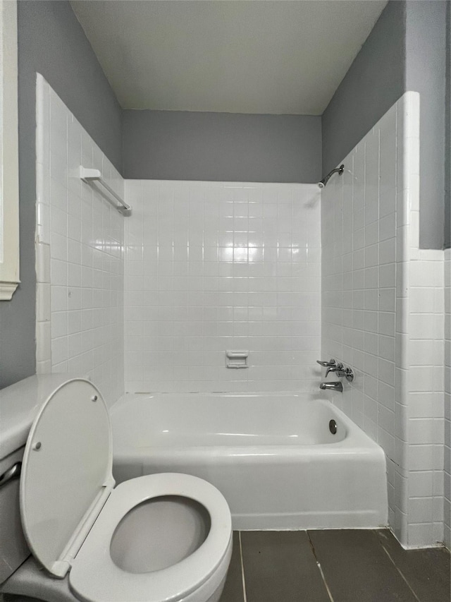 bathroom featuring tile patterned floors, toilet, and bathing tub / shower combination