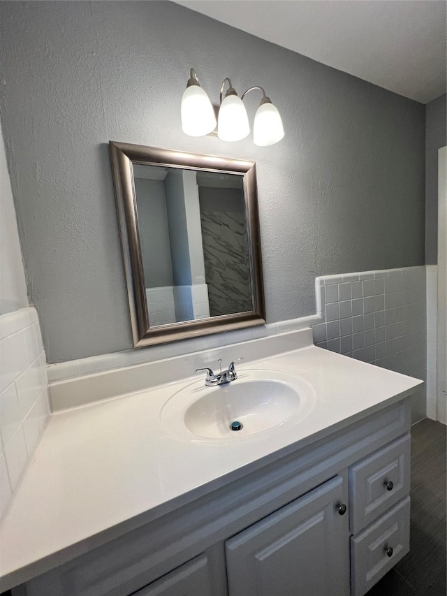 bathroom featuring vanity and a textured wall