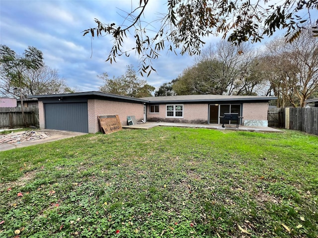 view of front of house with driveway, fence, a front yard, a garage, and brick siding