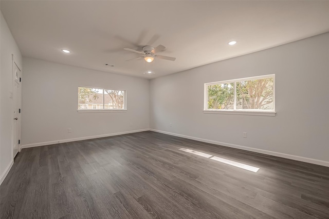 spare room featuring dark hardwood / wood-style flooring, ceiling fan, and a healthy amount of sunlight