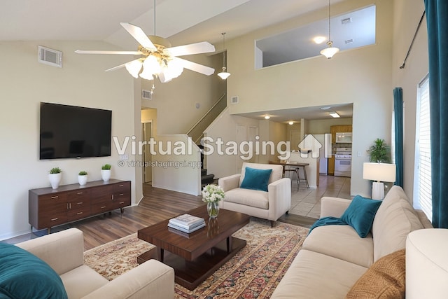 living room with ceiling fan, high vaulted ceiling, and hardwood / wood-style flooring