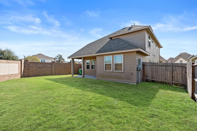 back of house with a patio area and a yard