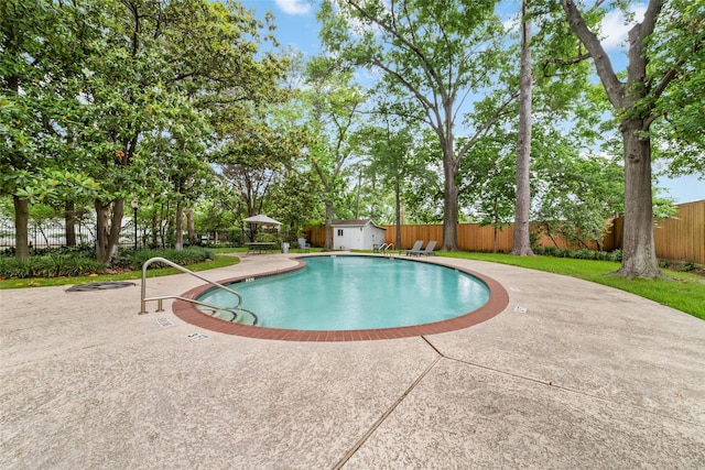 view of swimming pool featuring a storage shed and a patio