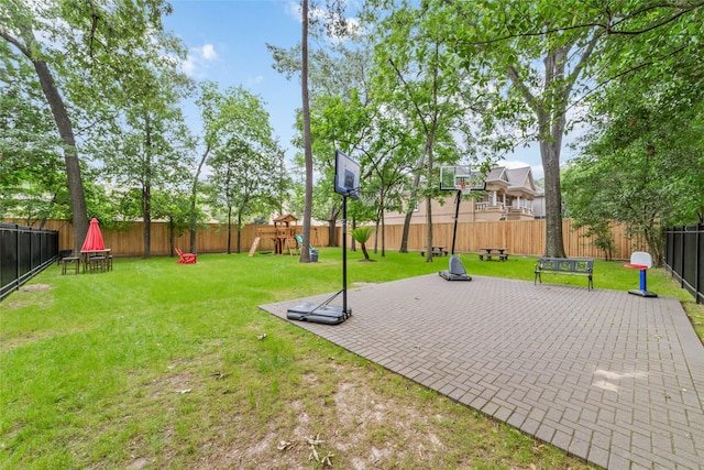 view of sport court featuring a playground and a yard