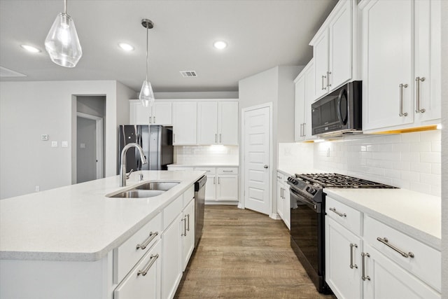 kitchen with sink, black appliances, pendant lighting, white cabinets, and an island with sink