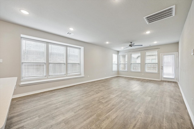 unfurnished living room featuring ceiling fan and light hardwood / wood-style flooring