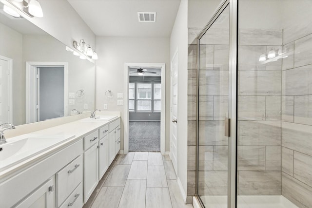 bathroom featuring ceiling fan, walk in shower, and vanity