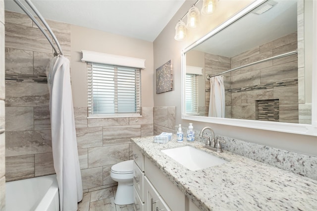 full bathroom with shower / tub combo with curtain, vanity, tile walls, and toilet