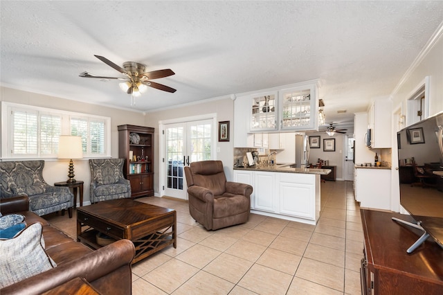 living room featuring a textured ceiling, light tile patterned flooring, crown molding, and french doors