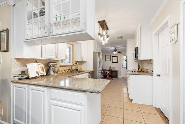 kitchen with white cabinetry, sink, ceiling fan, decorative light fixtures, and light tile patterned floors