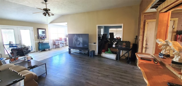 living room featuring hardwood / wood-style floors, lofted ceiling, french doors, ceiling fan, and a textured ceiling