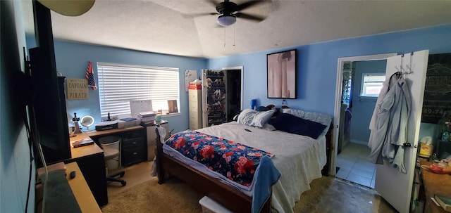 tiled bedroom featuring a textured ceiling and ceiling fan