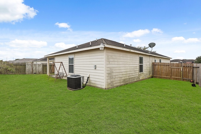 back of house featuring a lawn and central AC