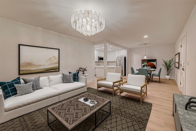 living room with light wood-type flooring and a chandelier