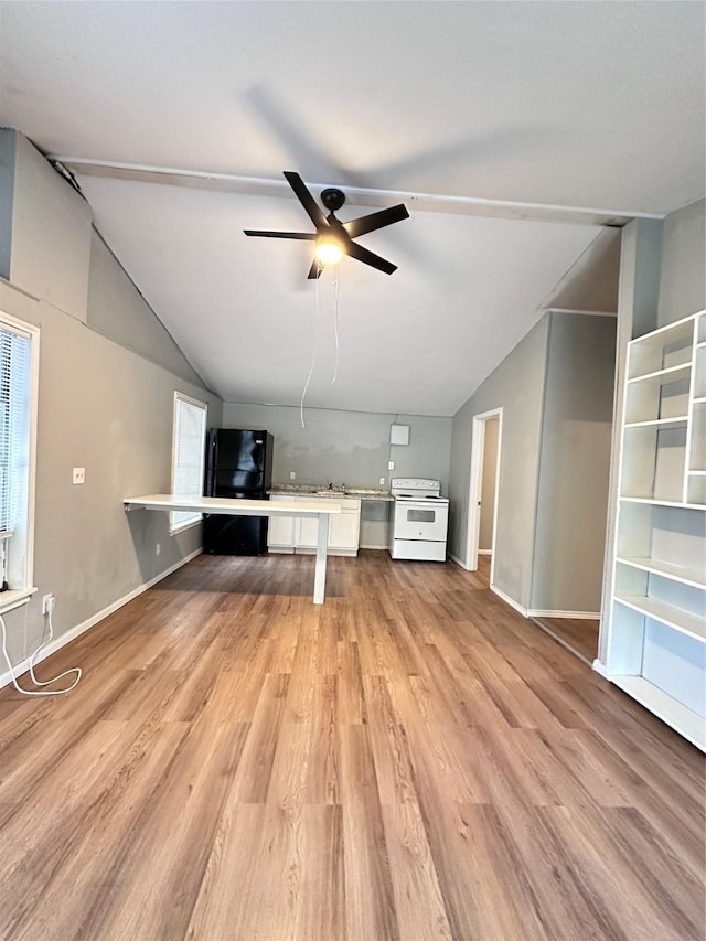 unfurnished living room featuring light hardwood / wood-style floors, vaulted ceiling, and ceiling fan