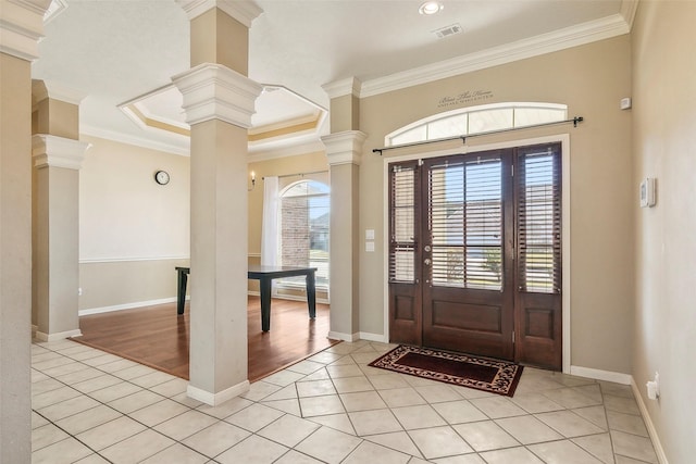 tiled entrance foyer with ornate columns and crown molding