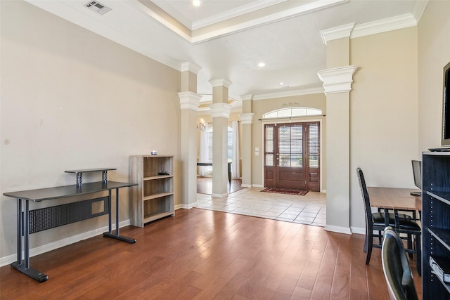 foyer featuring decorative columns, hardwood / wood-style flooring, and ornamental molding