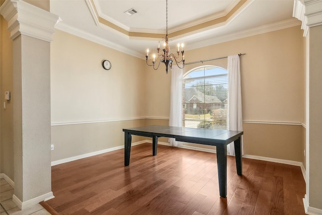 office area featuring hardwood / wood-style floors, a raised ceiling, crown molding, and a notable chandelier