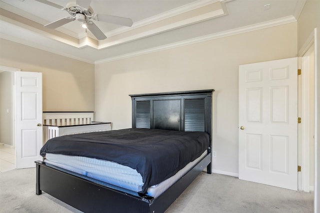 carpeted bedroom with a tray ceiling, ceiling fan, and crown molding