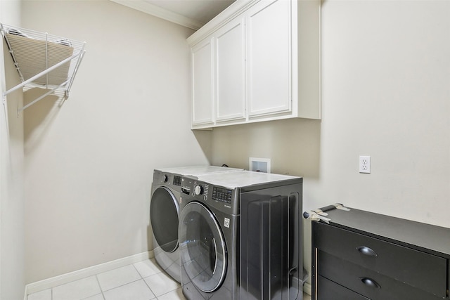 clothes washing area with cabinets, light tile patterned floors, washer and dryer, and ornamental molding