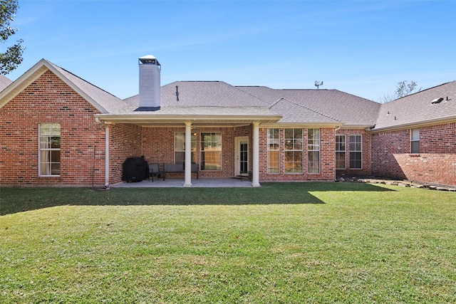 rear view of house with a patio area and a lawn