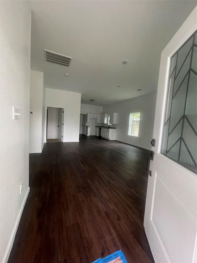 unfurnished living room with dark wood-type flooring