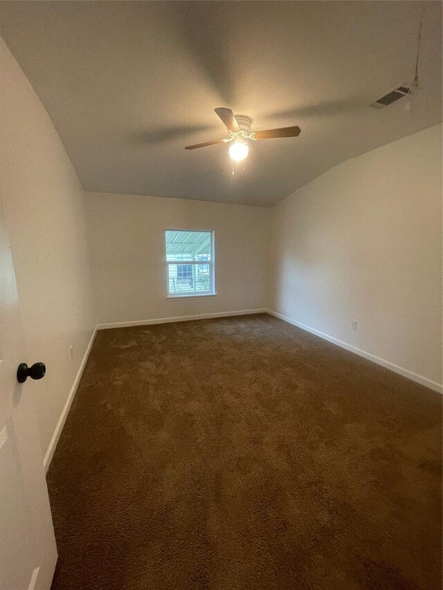 carpeted spare room featuring ceiling fan and vaulted ceiling