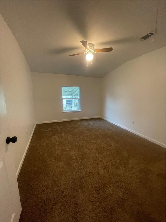 unfurnished room featuring dark colored carpet, ceiling fan, and vaulted ceiling