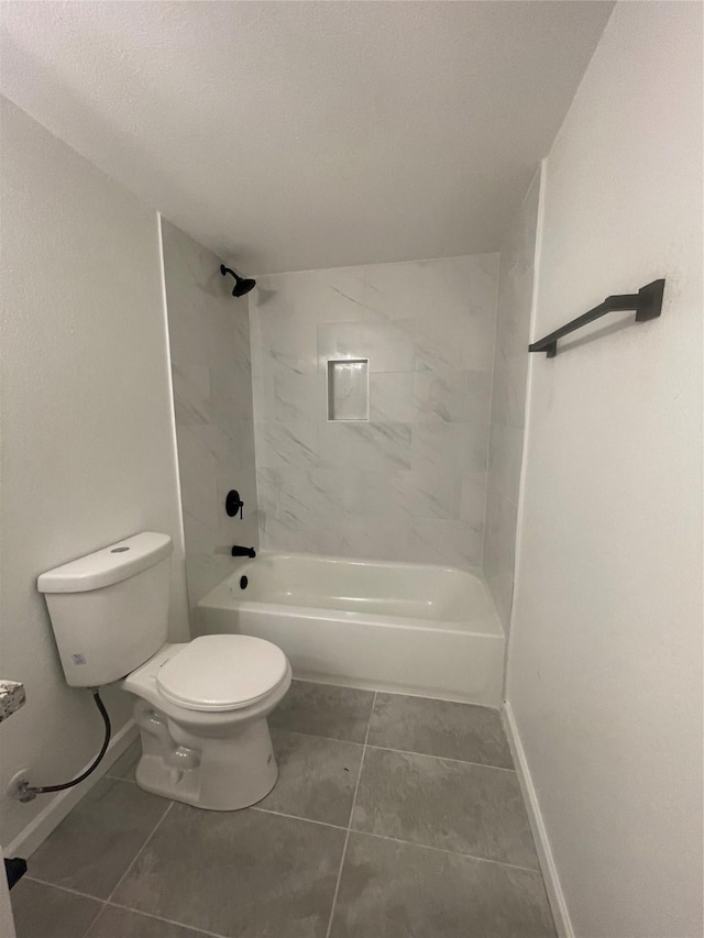 bathroom with tile patterned flooring, toilet, and tiled shower / bath