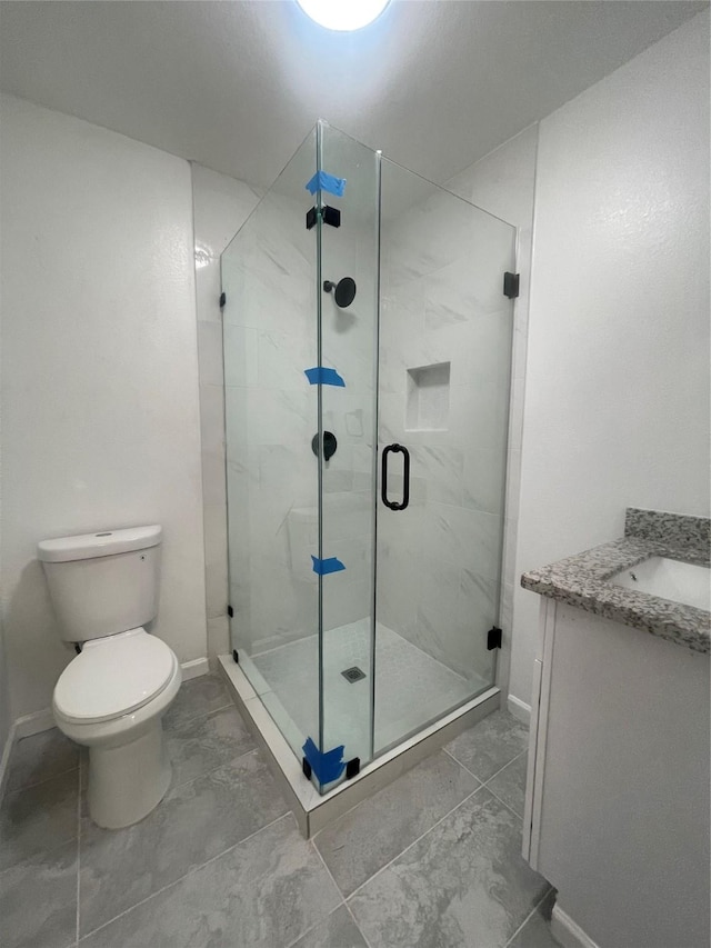 bathroom with an enclosed shower, vanity, and toilet