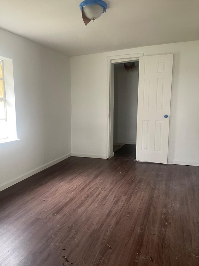 unfurnished bedroom featuring dark hardwood / wood-style flooring and a closet