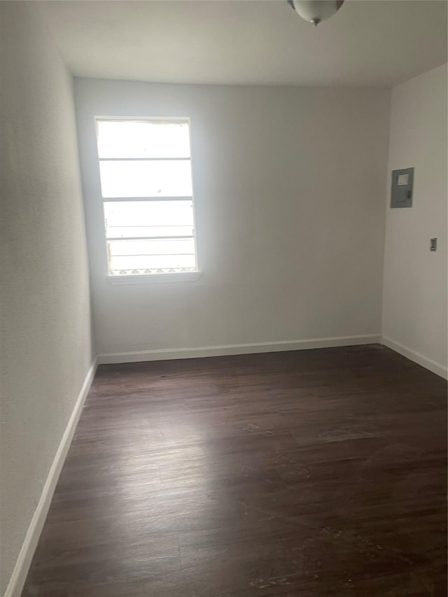 spare room featuring dark hardwood / wood-style flooring and electric panel