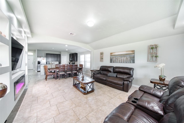 living room with light tile patterned flooring and vaulted ceiling