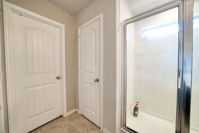 bathroom with a shower with door and tile patterned flooring