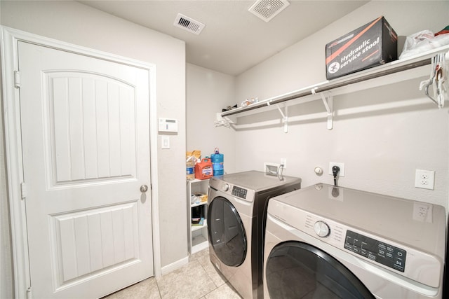 clothes washing area with light tile patterned flooring and independent washer and dryer