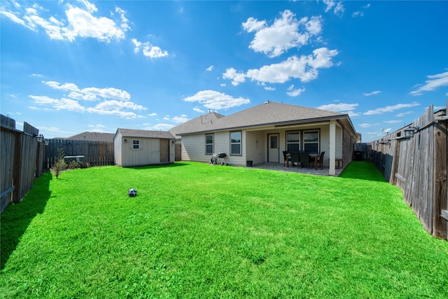 rear view of property with a patio area, a yard, and a storage shed