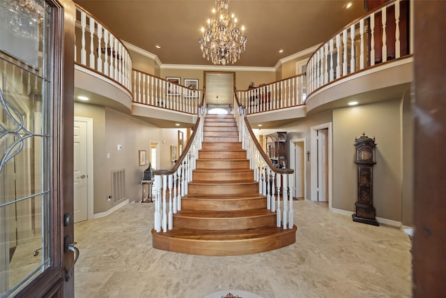 staircase featuring baseboards, a high ceiling, ornamental molding, and a chandelier