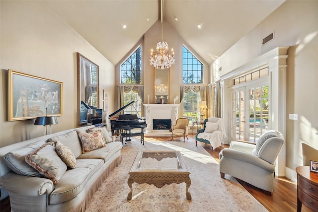 interior space with a notable chandelier, plenty of natural light, wood-type flooring, and high vaulted ceiling