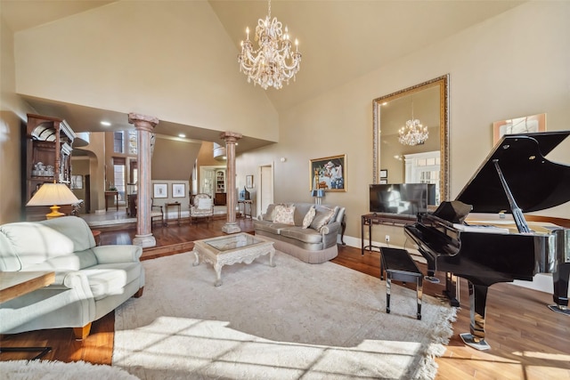 living room featuring decorative columns, high vaulted ceiling, a chandelier, and wood-type flooring