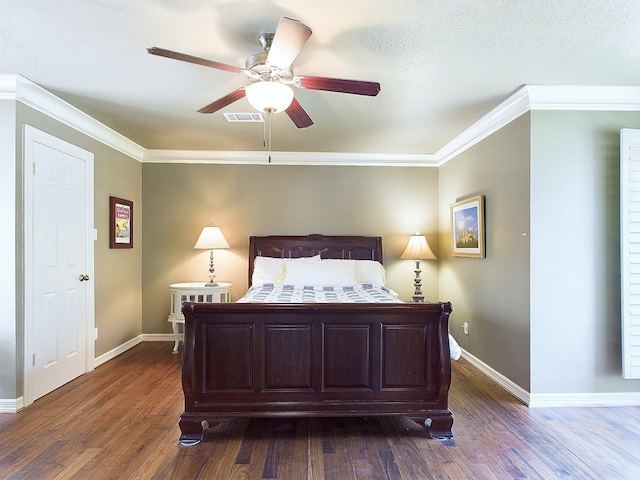 bedroom with ceiling fan, dark hardwood / wood-style flooring, ornamental molding, and a textured ceiling