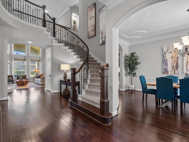 interior space featuring dark hardwood / wood-style flooring, ornamental molding, and a chandelier